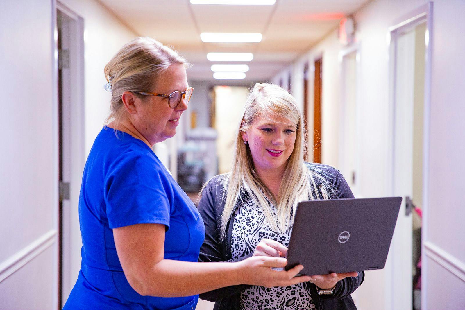 Jennifer Goldcamp, RN and director of nursing, and Lori Rose, RN, go over vaccine inventory on a computer.