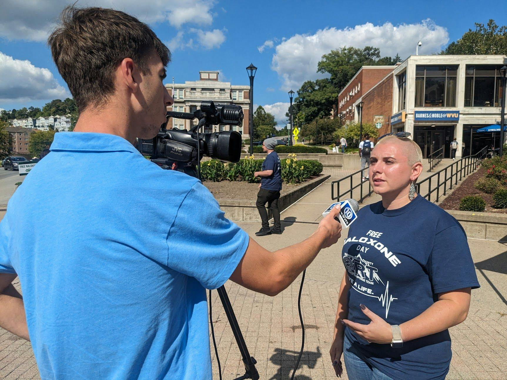 Brittany Irick talks to a TV reporter at a Free Naloxone Day in 2023